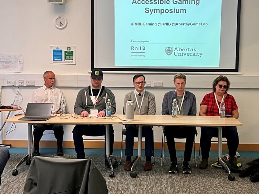 Photo of the&nbsp;Panel Discussion: Experience Of Playing Video Games With Vision Impairment at the symposium with Dave Williams as moderator, SightlessKombat as chair, and James Kyle, Jonathan Marshall and Jeanette Scott as panellists (Left to Right).